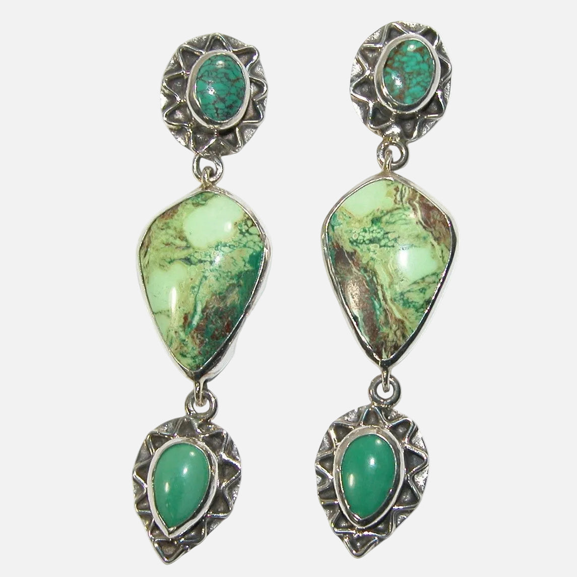 Pair of earrings with turquoise and gaspitite gemstones and sterling silver detailing on a white smoke background